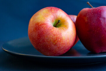 Red apples on a plate, closeup image.