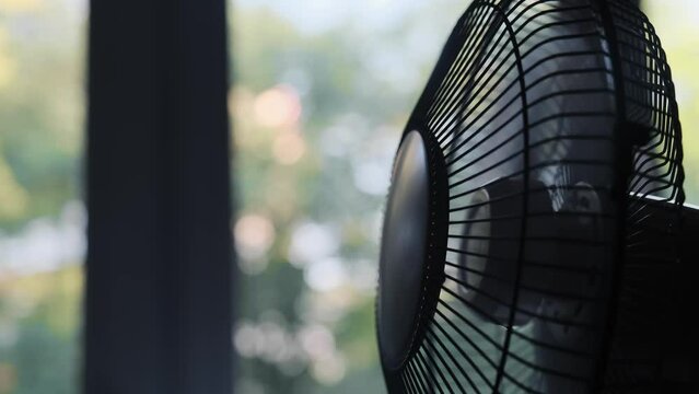 working portable office or home cooling fan in working mode is on the table.