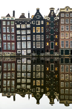 Building facades with a mirror image reflecting in a canal; Amsterdam, Netherlands