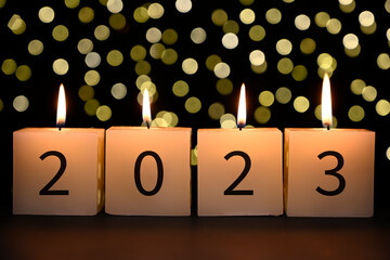 Candles with 2023 numbers. Concept of Happy new year with bokeh background.