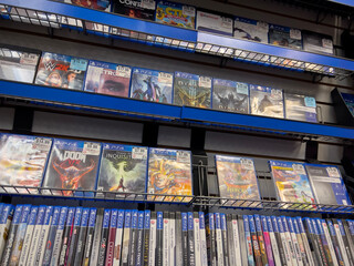 Naklejka premium Seattle, WA USA - circa December 2022: Selective focus on used video games for sale inside a GameStop gaming store.