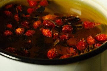 rose hips are brewed in a saucepan on a gas stove in the kitchen