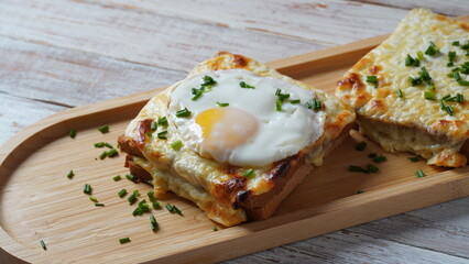 Hot French Traditional Croque madame and croque monsieur sandwiches for breakfast. Melted cheese and a fried egg