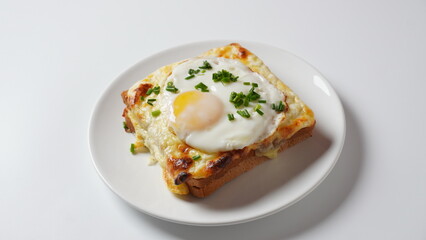 Hot French Traditional Croque madame sandwich for breakfast. Melted cheese and a fried egg on the top