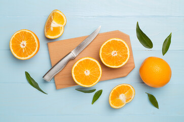 Flat lay with fresh oranges and leaves on wooden background