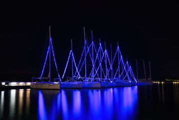 Christmas atmosphere and cityscape of the city of Volos with blue lights illuminating the boats and sailboats, decorating the beautiful beach town. Volos Magnesia, Greece
