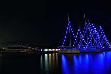 Christmas atmosphere and cityscape of the city of Volos with blue lights illuminating the boats and sailboats, decorating the beautiful beach town. Volos Magnesia, Greece