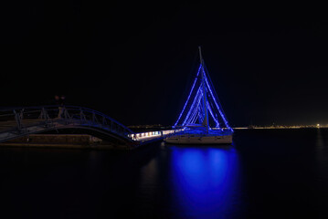 Christmas atmosphere and cityscape of the city of Volos with blue lights illuminating the boats and sailboats, decorating the beautiful beach town. Volos Magnesia, Greece