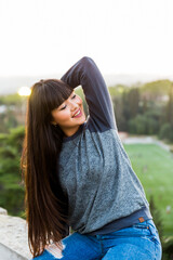 Pretty teenager woman having fun the a park of Barcelona, she smiles and enjoy nature and the view