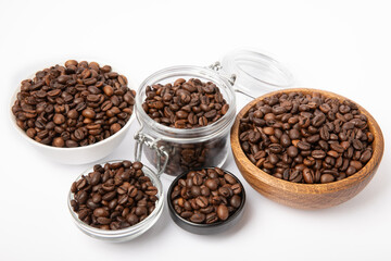 Bowls and jars with coffee beans isolated on white background.
