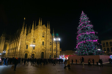Fototapeta na wymiar Panorama of the Piazza Duomo square on the New Year and Christmas tree. Albero di Natale with colored lights. City at night. One night ahead. Multi-colored lights. Milan, Italy, December 