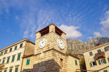 Fototapeta na wymiar Montenegro. View of Old Town of Kotor - UNESCO World Heritage site. Ancient buildings against sky. Clock Tower