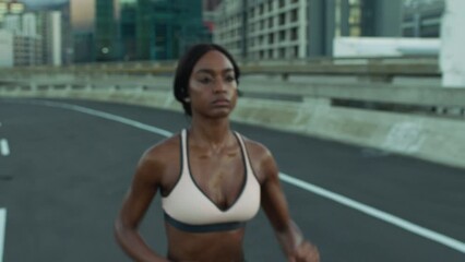 Runner, fitness or black woman running on road, street or asphalt training for a marathon or triathlon in a city. Wellness, girl or healthy sports athlete in a cardio exercise or workout in Detroit