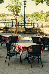 Vertical photo of some tables and chair from a cafe terrace in Europe on a summer day.