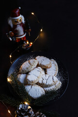Ricciarelli, dolce natalizio a base di mandorle su fondo scuro. Decorazioni natalizie. Dolci della tradizione italiana.