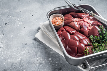 Fresh Raw Beef veal kidney in kitchen tray. Gray background. Top view. Copy space