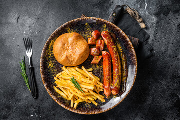 German currywurst sausage, curry wurst served with French fries. Dark background. Top view