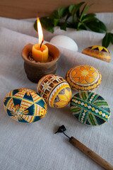 Fototapeta premium Ukrainian Easter eggs, rstka and candle on the background of linen fabric