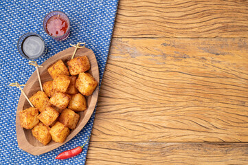 Tapioca dice, typical northeast brazilian food with sugar and pepper syrup over wooden table with copy space