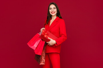 Fototapeta na wymiar attractive woman in red with shopping bags sale on red background