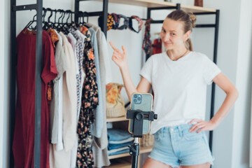 Woman blogger using mobile camera with tripod making video content for her vlog