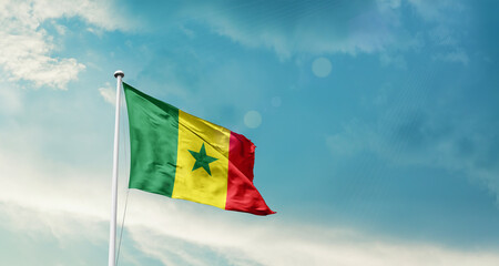 Waving Flag of Senegal in Blue Sky. The symbol of the state on wavy cotton fabric.