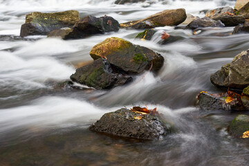 Fototapeta na wymiar creek with soft flowing waterfalls and rocks