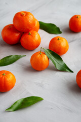 Raw Organic Mandarins on a gray background, low angle view.