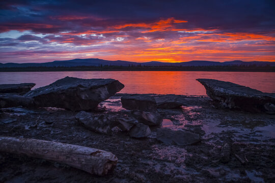 Sunset over icebergs on the Yukon River at Slaven's Roadhouse in summertime, Yukon-Charley Rivers National Preserve; Alaska, United States of America