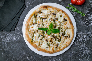 Pizza with chicken and mushrooms top view on dark table