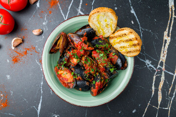 Mussels in tomato sauce on marble table top view