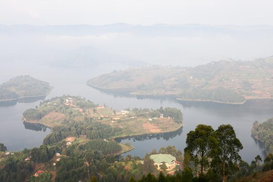 An early morning fog and haze cover the islands and hills of Lake Bunyonyi.; Lake Bunyonyi, Uganda