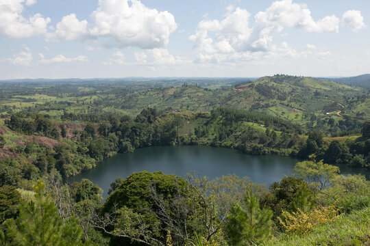 One of several crater lakes in Kibale National Park is visible amongst vast vegetation.; Kibale National Park, Uganda