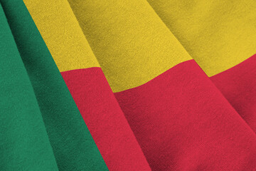 Benin flag with big folds waving close up under the studio light indoors. The official symbols and...