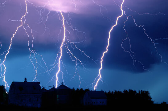 Lightning strikes fill the night sky over a farm and barn rooftop, near Walton, Nebraska, USA; Walton, Nebraska, United States of America