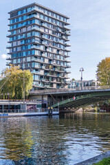 Schleswiger Ufer with an arch bridge Hansabruecke and the Oasis Tower in Berlin, Germany