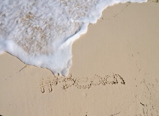 #Beach written at caribbean beach with sea foam approaching