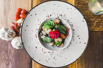Top view of pasta dish. Black tagliolini pasta with prawns on white plate. Garlic and hot peppers for decoration. High quality photo
