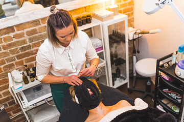 Top view of a woman having spa facial massage with towel in a beauty salon. High quality photo