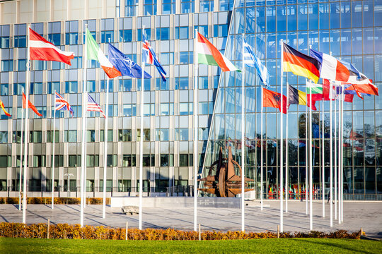 NATO building headquarters with flags and symbol outside
