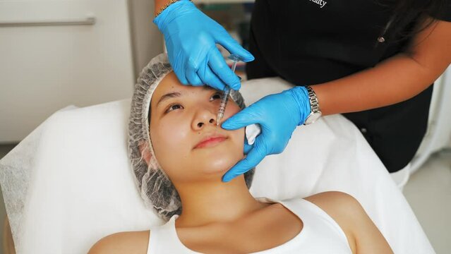 charming Asian woman getting mesotherapy and injection on the forehead at the spa, beauty care concept. High quality 4k footage