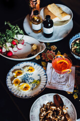 high angle view of table full of food and drink: eggs, pasta, mushrooms, beans, radishes, spring meal, cocktail