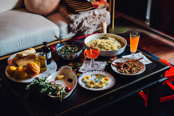 table full of vegetarian food and drinks: eggs, pasta, mushrooms, beans, radishes, spring meal, cocktails