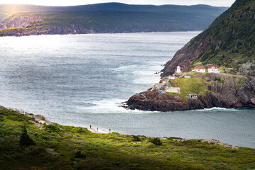 Fort Amherst Lighthouse historic site photograph taken from Signal hill with tourists overlooking a cliff near St. John's Newfoundland Canada.