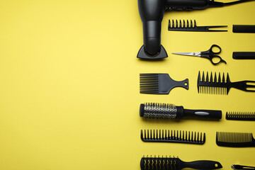 Flat lay composition of professional hairdresser tools on yellow background, space for text