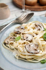 Delicious pasta with mushrooms and cheese on table, closeup