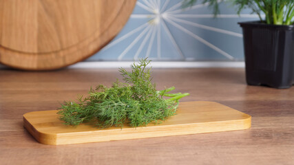 Fresh green dill on wooden table in kitchen