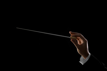 Professional conductor with baton on black background, closeup