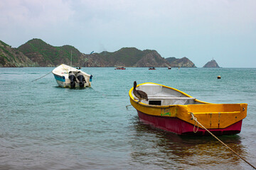 Fototapeta na wymiar botes en la playa y montañas con el mar