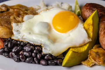 Close up of Bandeja paisa, typical food of Colombia with egg, beans and rice.